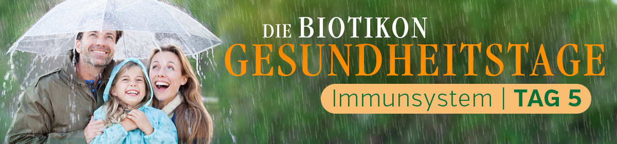 Sistema Immunitario – Giorni della Salute Biotikon Giorno 5 Famiglia sotto la pioggia con un ombrello, volti felici, sfondo naturale, evento orientato alla salute.