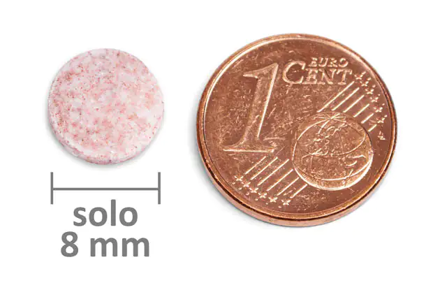 Multivitaminico 8 mm – Compresse Compressa multivitaminica rotonda di colore rosa con un diametro di 8 mm, accanto a una moneta da 1 centesimo per riferimento alla dimensione.